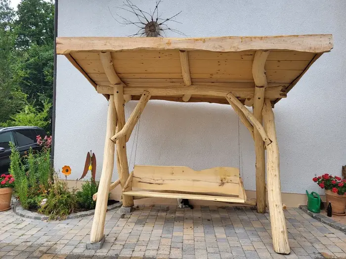 Überdachte Holzschaukel mit rustikalem Ständerwerk