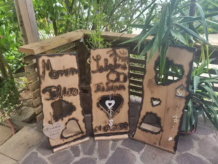 Geschnitzte Holztafeln mit Namen und Herzmotiven